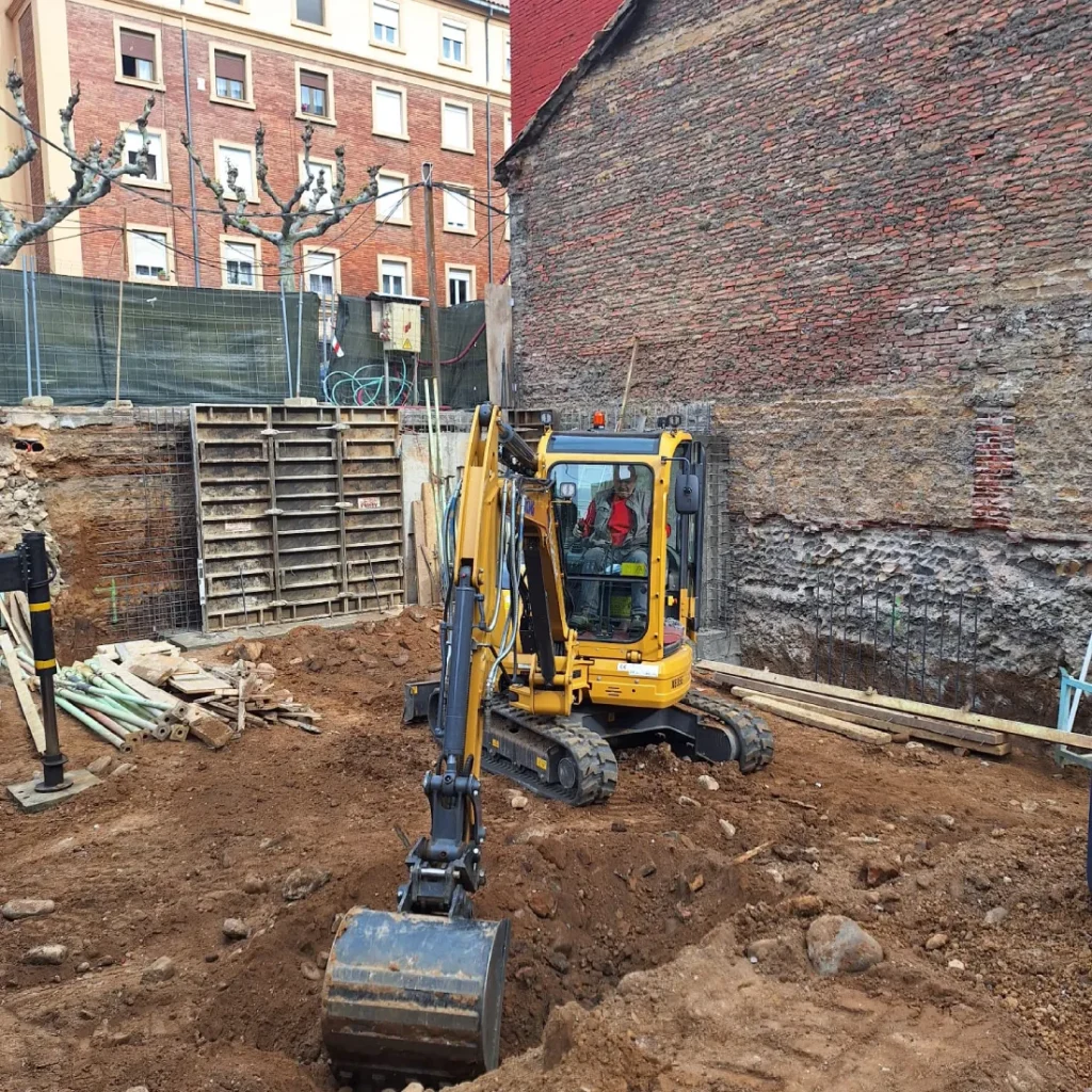 Miguel Oblanca – Maquina excavadora en funcionamiento Excavadora en acción realizando movimientos de tierra en un solar de León, Miguel Oblanca S.L. - expertos en maquinaria de obra
